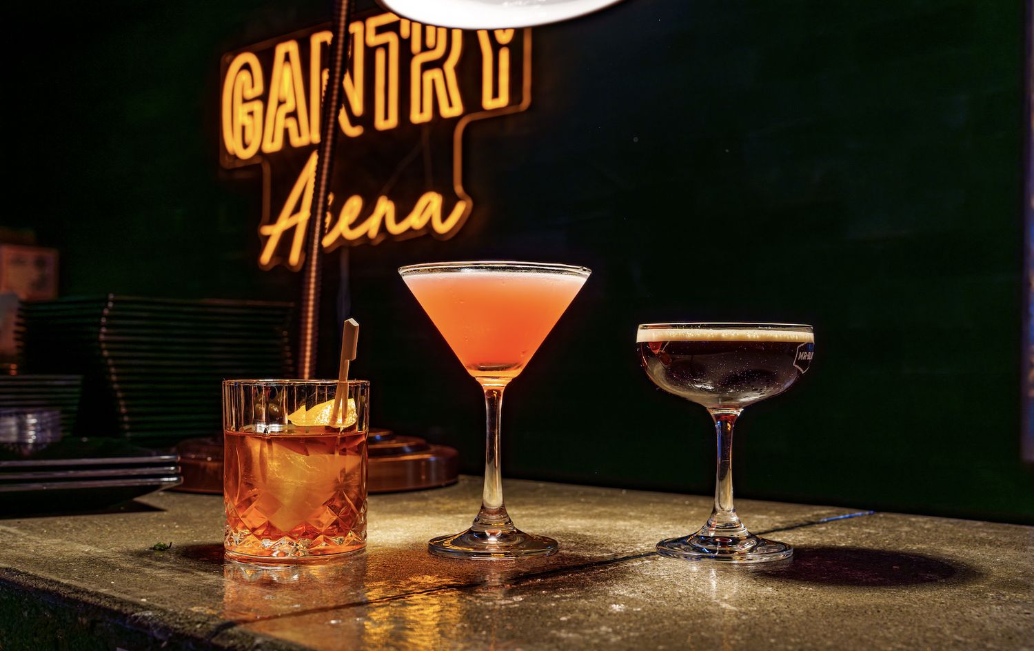 Gantry Arena neon sign behind craft cocktails